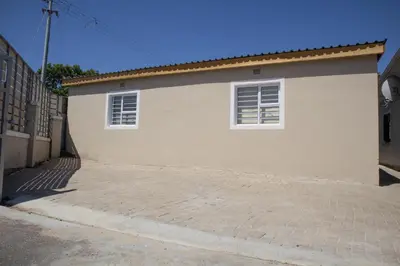 a white house with two windows and a driveway at One Bedroom apartment A3 in Cape Town