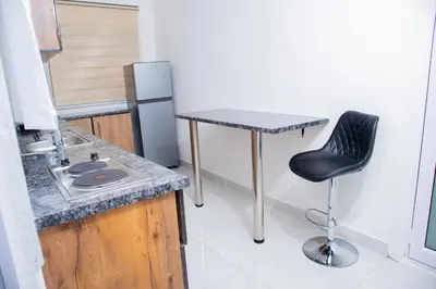 a small kitchen with a black chair and a table at One Bedroom Apartment A4 in Cape Town