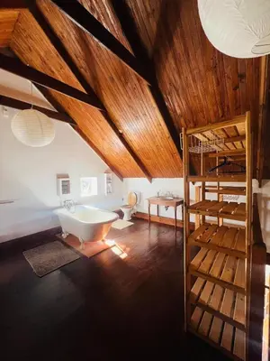 a attic room with a tub and a bunk bed at 9de Laan Kleinmond in Kleinmond
