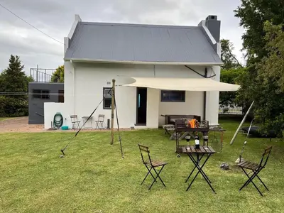 a house with a table and chairs and a fire at 9de Laan Kleinmond in Kleinmond