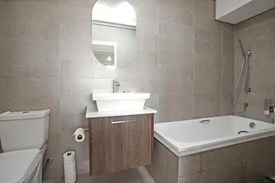 a bathroom with a sink and a tub and a toilet at Waters Edge Uno in Cape Town