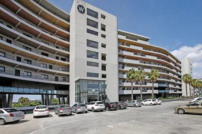 a parking lot with cars parked in front of a building at Waters Edge Uno in Cape Town
