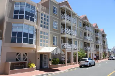 a building on a street with cars parked in front at Yellow Couch Studio Apartment 1 KingBed in Cape Town