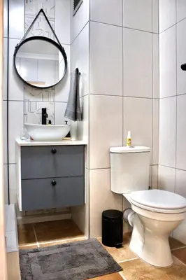 a bathroom with a sink and a toilet and a mirror at Yellow Couch Studio Apartment 1 KingBed in Cape Town