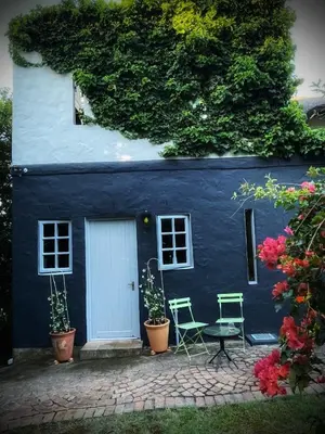 a blue house with two chairs and a table at The Secret Room in Somerset West