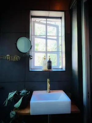 a bathroom with a white sink and a window at The Secret Room in Somerset West