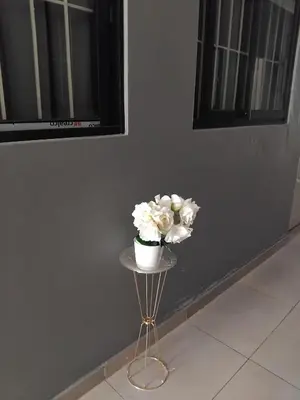 a small table with a vase of flowers on it at The Gem Guest House & Spa in Parow