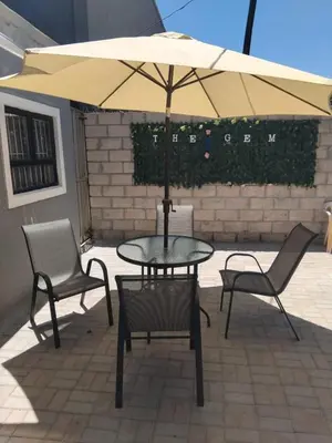 a table and two chairs and an umbrella on a patio at The Gem Guest House & Spa in Parow