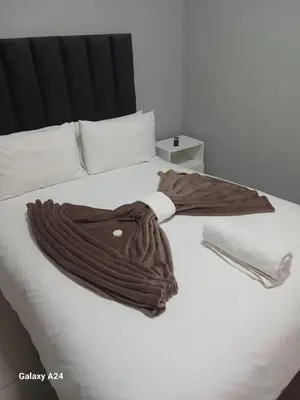 a blanket is laying on a white bed at The Gem Guest House & Spa in Parow