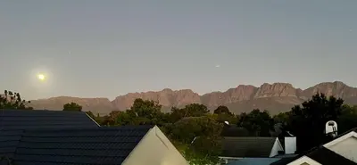 a view of a mountain range with buildings and trees at Vendôme in Somerset West