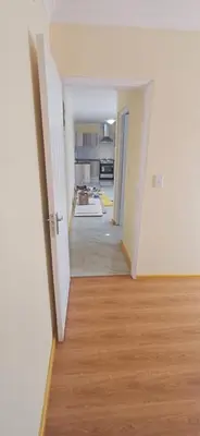 an empty room with a hallway leading to a kitchen at Cosy Cove in Grassy Park