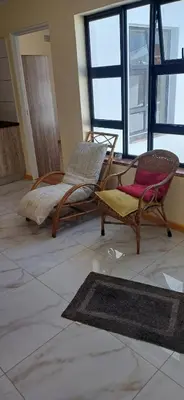 a living room with two chairs and a bed at Cosy Cove in Grassy Park