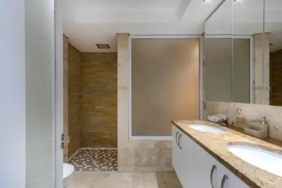 a bathroom with two sinks and a shower at Atlantica202 in Strand