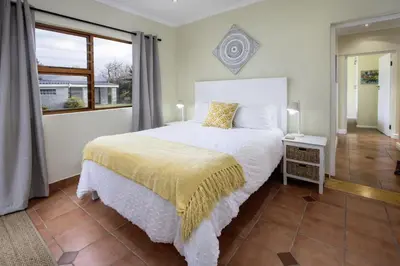 a bedroom with a white bed and a window at Fisherhaven in Hermanus