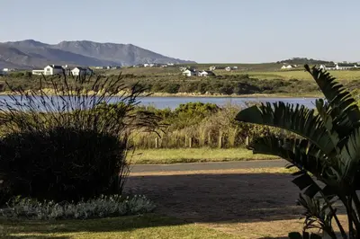 a view of a body of water with mountains in the background at Fisherhaven in Hermanus