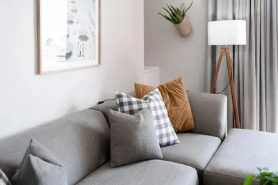 a gray couch with pillows in a living room at Seabreeze at the Beach in Strand