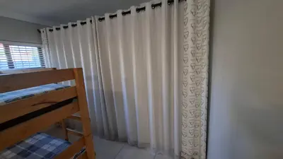 a bedroom with a curtain and a bunk bed at Coco Cabana in Kleinmond