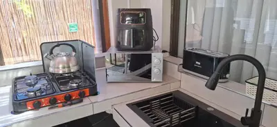 a kitchen counter with a stove and a tea kettle at Coco Cabana in Kleinmond