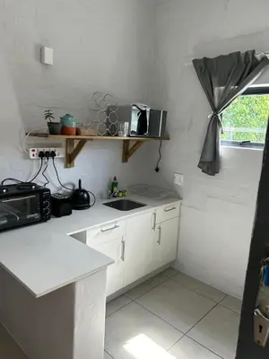 a white kitchen with a sink and a window at Seewind in Hermanus