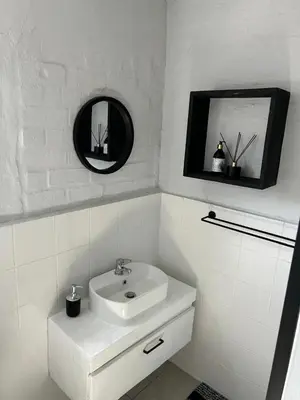 a white bathroom with a sink and a mirror at Seewind in Hermanus