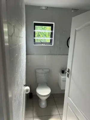 a small bathroom with a toilet and a window at Seewind in Hermanus