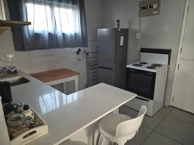 a kitchen with a white counter and a refrigerator at Seewind in Hermanus