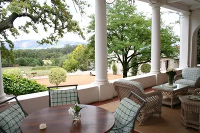 a porch with a table and chairs and a view at Diemersfontein Wine & Country Estate in Wellington