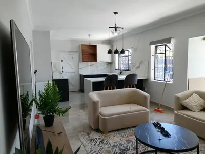 a living room with a couch and a table at Urban Sleek Black Haven in Cape Town