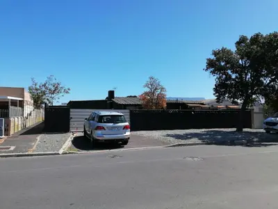 a car parked in a parking lot next to a fence at Urban Sleek Black Haven in Cape Town