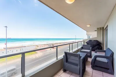 a balcony with chairs and a view of the beach at Sea Spray B303 by CTHA in Cape Town