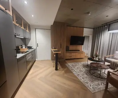 a kitchen and a living room with a table at 308 Bridgewater One - Two Bedroom Apartment with Park Views in Cape Town