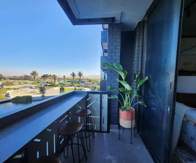 a bar with stools and a plant on a balcony at 308 Bridgewater One - Two Bedroom Apartment with Park Views in Cape Town