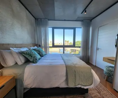 a bedroom with a large bed with a large window at 308 Bridgewater One - Two Bedroom Apartment with Park Views in Cape Town