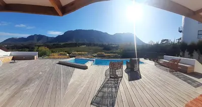 a deck with a swimming pool on top of a house at 3 Jongens Villa in Voëlklip