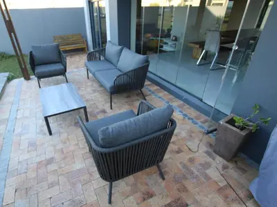 a patio with chairs and a couch and a table at Misty Mountain in Strand