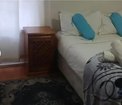 a small bedroom with a bed and a night stand at 151 Gie Road in Cape Town
