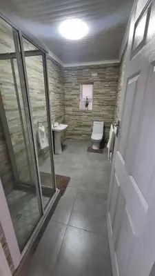 a bathroom with a toilet and a sink and a window at Acanthus Circle in Cape Town
