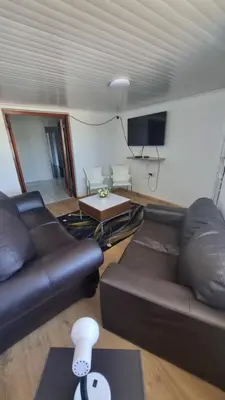 a living room with a leather couch and a tv at Acanthus Circle in Cape Town