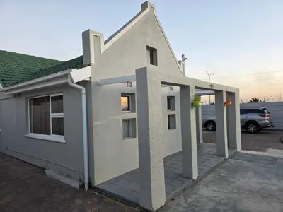 a small white house with an open door at Acanthus Circle in Cape Town