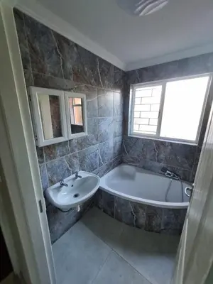 a bathroom with a bath tub and a sink at Acanthus Circle in Cape Town