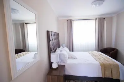 a bedroom with a bed and a mirror at Cape Dreamland in Cape Town