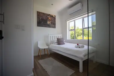 a small bedroom with a bed and a window at theLAB Luxury Backpackers in Franschhoek