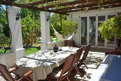 a dining table and chairs on a patio at Lovely Family Home in the Winelands in Cape Town