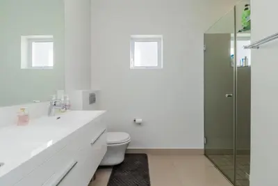 a white bathroom with a toilet and a glass shower at Val de Vie in Simondium