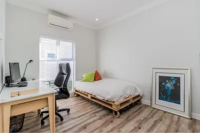 a bedroom with a bed and a desk and a computer at Val de Vie in Simondium