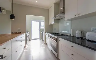 a kitchen with white cabinets and a stove top oven at Val de Vie in Simondium