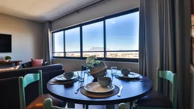 a dining room with a table and a large window at Budapest Boutique Hotel in Edgemead