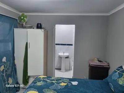 a bedroom with a bed and a bathroom with a sink at 27 on Milton in Cape Town
