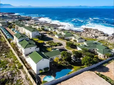 an aerial view of a resort with the ocean at Whale Rock Estate Four 1 in Hermanus