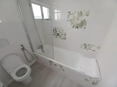 a white bathroom with a toilet and a shower at Whale Rock Estate Four 1 in Hermanus